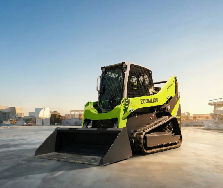 Chargeuse compacte verte et noir sur une surface en béton, avec un ciel clair en arrière-plan.